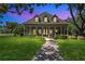 Stunning single-Gathering home with a beautiful manicured lawn, inviting porch, and mature trees under a colorful sky at 19554 Spring Oak Dr, Eustis, FL 32736