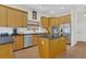 Well-lit kitchen with tiled floors, island with stovetop, wood cabinets, and stainless steel appliances at 19554 Spring Oak Dr, Eustis, FL 32736