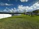 Expansive backyard with a view of a tranquil lake, complemented by a pristine white fence at 1982 King Ranch St, Kissimmee, FL 34744