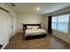 Bright bedroom with a view and a black accent headboard, plus wood-look flooring at 1982 King Ranch St, Kissimmee, FL 34744