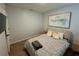 Comfortable bedroom featuring stylish gray bedding, neutral decor, and wood-look flooring at 1982 King Ranch St, Kissimmee, FL 34744