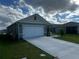 Attractive one-story home showcases a two-car garage, a long concrete driveway, and verdant lawn at 1982 King Ranch St, Kissimmee, FL 34744