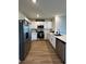 Well-lit kitchen with stainless steel appliances, white cabinets, and a kitchen island at 1982 King Ranch St, Kissimmee, FL 34744