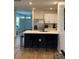 Stylish kitchen island with black stools and white cabinets, adjacent to the entry at 1982 King Ranch St, Kissimmee, FL 34744