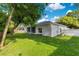 Spacious backyard featuring lush green grass and a white stucco home at 2024 Flaming Arrow Ct, Fern Park, FL 32730
