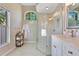 Bright bathroom with a glass shower, white vanity, and decorative window for natural lighting at 2024 Flaming Arrow Ct, Fern Park, FL 32730
