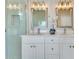 Bathroom with dual sinks, white vanity, mirrors, and a glass door shower at 2024 Flaming Arrow Ct, Fern Park, FL 32730