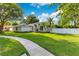 Well-maintained home featuring green lawn, side fence, sidewalk, and mature trees on a sunny day at 2024 Flaming Arrow Ct, Fern Park, FL 32730