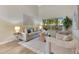 Cozy living room features hardwood floors, neutral furniture, and a large window with backyard views at 2024 Flaming Arrow Ct, Fern Park, FL 32730