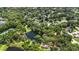 An aerial view of a community showcasing a pond, tennis courts, lush greenery, and single-Gathering homes at 205 Stevenage Dr, Longwood, FL 32779
