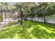 Spacious backyard with lush lawn, mature trees, and screened-in pool area at 205 Stevenage Dr, Longwood, FL 32779
