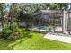 Lush green backyard with a screened-in pool area and mature trees at 205 Stevenage Dr, Longwood, FL 32779