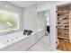 Luxurious bathroom features a soaking tub, tiled accent wall, and updated fixtures at 205 Stevenage Dr, Longwood, FL 32779
