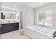 Bright bathroom features a soaking tub and dual sink vanity with marble tile at 205 Stevenage Dr, Longwood, FL 32779