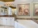 Bright bathroom with granite counters, a soaking tub and a large decorative painting at 2055 S Atlantic Ave # 1410, Daytona Beach Shores, FL 32118