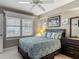 Bedroom with ceiling fan, dresser, mirror, bed with patterned pillows and large window at 2055 S Atlantic Ave # 1410, Daytona Beach Shores, FL 32118