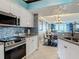 This open concept kitchen features white cabinets, stainless steel appliances, and granite countertops at 2055 S Atlantic Ave # 1410, Daytona Beach Shores, FL 32118