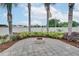 Brick paved patio with fire pit and privacy fence surrounded by greenery and palm trees at 2406 Sweetwater Blvd, St Cloud, FL 34772