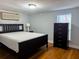 Serene bedroom with black bed frame, dark wood floors, and window with blinds, creating a restful and comfortable retreat at 2515 Marlboro St, Orlando, FL 32806