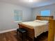Cozy bedroom with a wooden sleigh bed, bench, and light-filled windows, offering a comfortable and relaxing atmosphere at 2515 Marlboro St, Orlando, FL 32806
