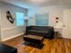 Cozy living room featuring hardwood floors, a comfortable couch, and ample natural light at 2515 Marlboro St, Orlando, FL 32806
