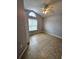 Empty bedroom featuring neutral tones, a ceiling fan, and an arched window at 2817 Moultrie Creek Dr, Kissimmee, FL 34743