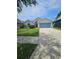 Well-manicured lawn complements this single-Gathering home with a spacious driveway and welcoming façade at 2817 Moultrie Creek Dr, Kissimmee, FL 34743