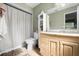 Bathroom featuring a vanity with wood cabinets, white walls, tile floor, and shower with tub at 303 Mariana Way, Kissimmee, FL 34758