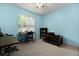 Cozy bedroom with natural light from the window, complemented by a desk and bookcase at 303 Mariana Way, Kissimmee, FL 34758