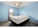 Inviting bedroom with a plush bed, ceiling fan, and ample natural light at 303 Mariana Way, Kissimmee, FL 34758