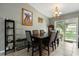 Elegant dining room with a large table, chandelier, and sliding glass doors to the backyard at 303 Mariana Way, Kissimmee, FL 34758