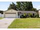 Charming single-story home with a well-maintained lawn and attached two-car garage at 303 Mariana Way, Kissimmee, FL 34758