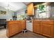 Spacious kitchen with wooden cabinets, a dishwasher, and an open view of the dining area at 303 Mariana Way, Kissimmee, FL 34758