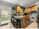Functional kitchen with wooden cabinets, breakfast bar seating, and stainless-steel appliances at 303 Mariana Way, Kissimmee, FL 34758
