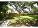 Large backyard with a privacy fence and mature trees, perfect for outdoor activities at 3519 Amigos Ave, Orlando, FL 32808