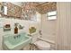 Charming bathroom boasts colorful floral wallpaper, a green sink, and a shower-tub combination at 3519 Amigos Ave, Orlando, FL 32808