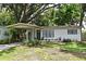 Charming single-story home with a quaint, landscaped front yard and a welcoming covered entrance with an olive colored front door at 3519 Amigos Ave, Orlando, FL 32808