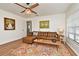 Comfortable living room featuring a plush leather sofa, stylish rug, and abundant natural light, perfect for relaxation at 3519 Amigos Ave, Orlando, FL 32808