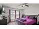 A spacious bedroom with a purple bed, fan, and bright windows at 3565 Sw Idlewild St, Dunnellon, FL 34431