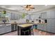 Well-lit kitchen features stainless steel appliances, grey cabinets and a butcher block island with bar stools at 3565 Sw Idlewild St, Dunnellon, FL 34431