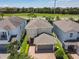 Aerial view of a suburban home with a paver driveway and lush green landscaping at 370 Pendant Ct, Kissimmee, FL 34747