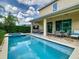 Beautiful backyard featuring a sparkling pool, covered patio, and landscaped surroundings at 370 Pendant Ct, Kissimmee, FL 34747