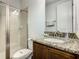 A modern bathroom features a granite countertop, wood cabinetry, and a glass-enclosed shower at 370 Pendant Ct, Kissimmee, FL 34747