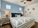 Cozy bedroom featuring a queen bed, wood floors, ceiling fan and stylish coastal decor at 370 Pendant Ct, Kissimmee, FL 34747