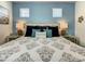 A serene bedroom features soft blue walls, two windows, and a plush bed with decorative pillows at 370 Pendant Ct, Kissimmee, FL 34747