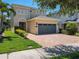 Inviting home exterior featuring a paver driveway, a two-car garage, and manicured landscaping at 370 Pendant Ct, Kissimmee, FL 34747