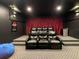 A home theater room features tiered seating, a large screen, and dark walls for an immersive viewing experience at 370 Pendant Ct, Kissimmee, FL 34747