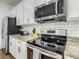 Bright kitchen featuring white cabinets, granite countertops, and stainless steel appliances at 370 Pendant Ct, Kissimmee, FL 34747