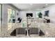 Granite kitchen island featuring a stainless steel sink, modern faucet and lots of natural light at 370 Pendant Ct, Kissimmee, FL 34747