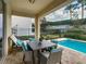 Charming outdoor dining area with a table and chairs, ideal for al fresco meals by the pool at 370 Pendant Ct, Kissimmee, FL 34747